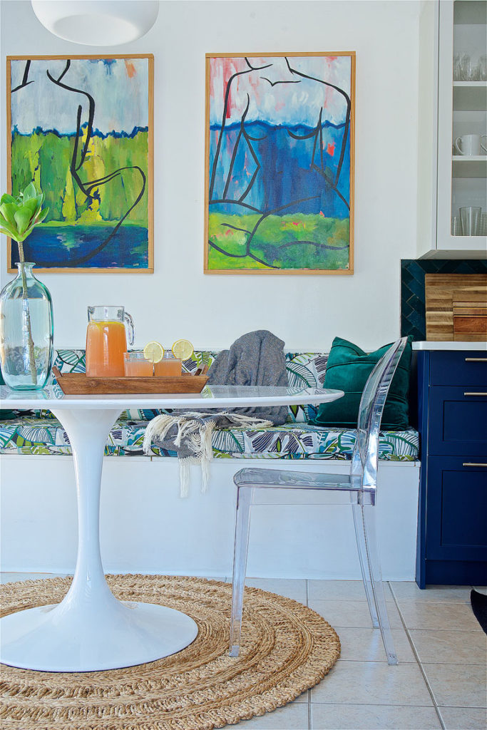 Midcentury modern and bohemian influenced dining room alongside a navy blue kitchen by Denver based interior designer Fernway & Avalon.